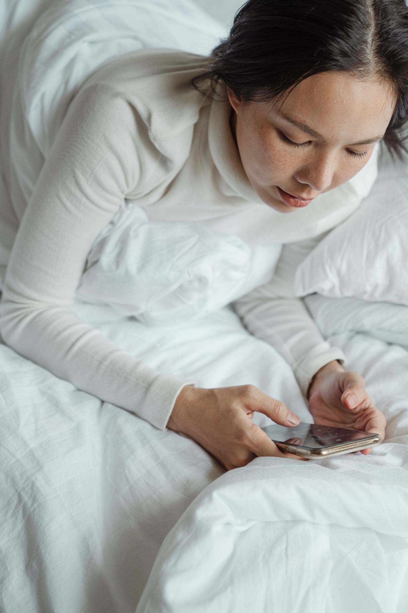 Personne consultant son téléphone au lit dans le noir