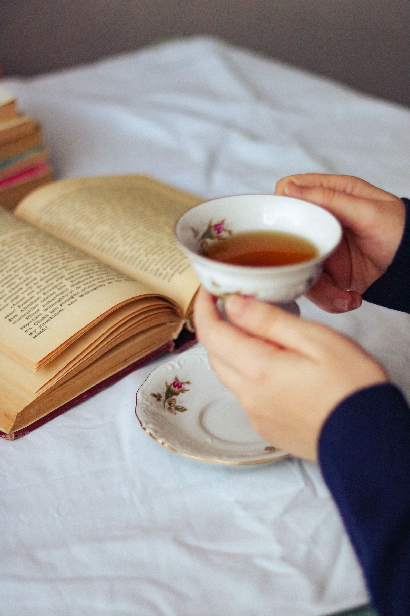 Femme buvant une tasse de thé en lisant, moment calme de pause