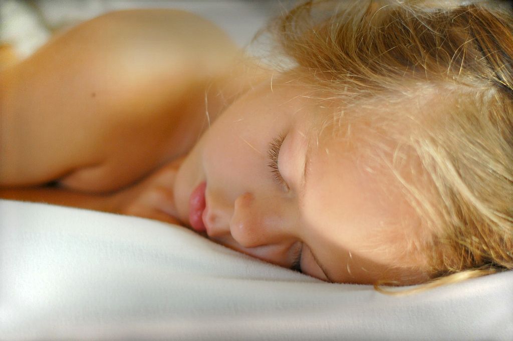 Jeune femme endormie paisiblement dans son lit