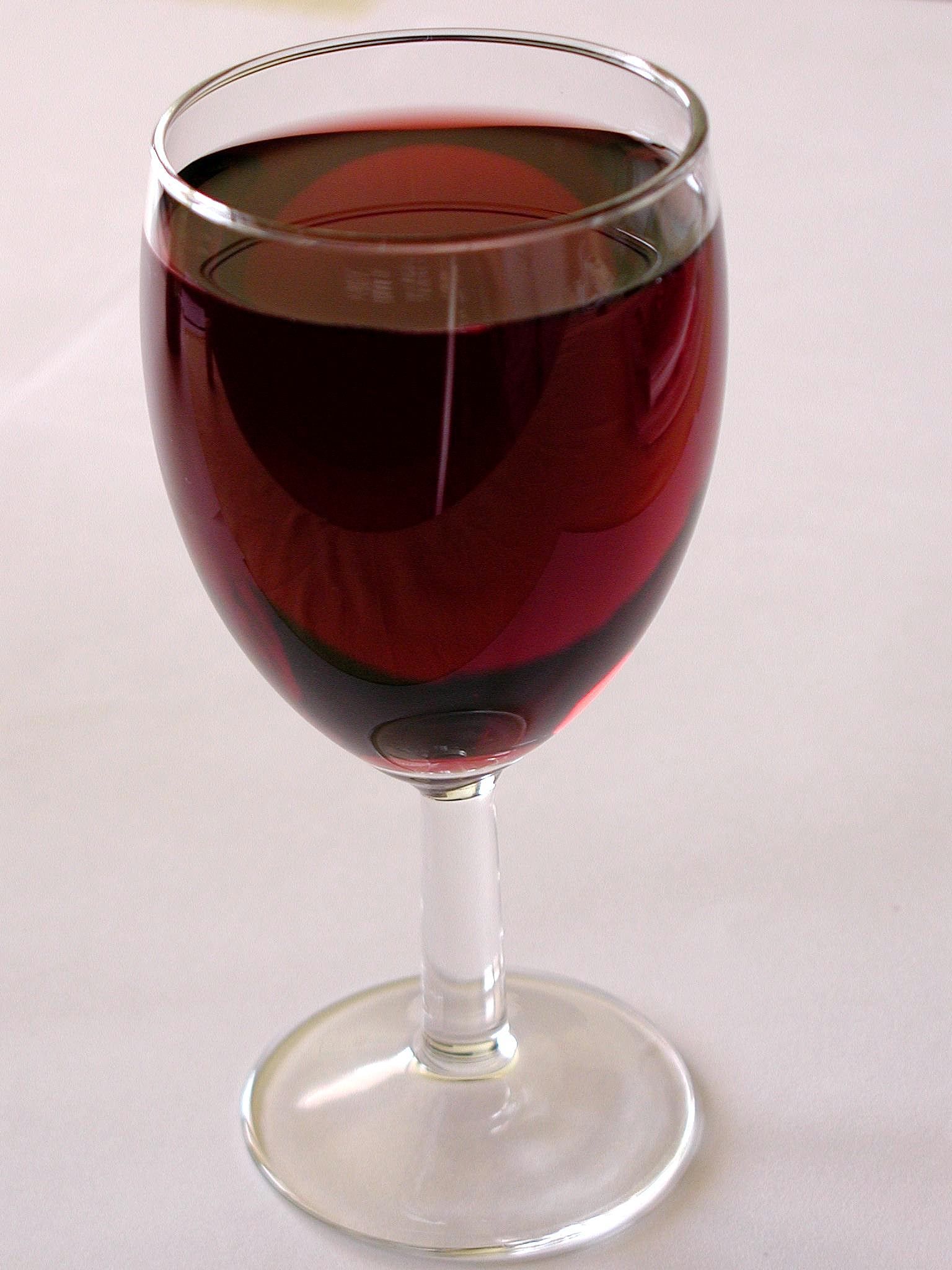 Verre de vin rouge posé sur une surface claire